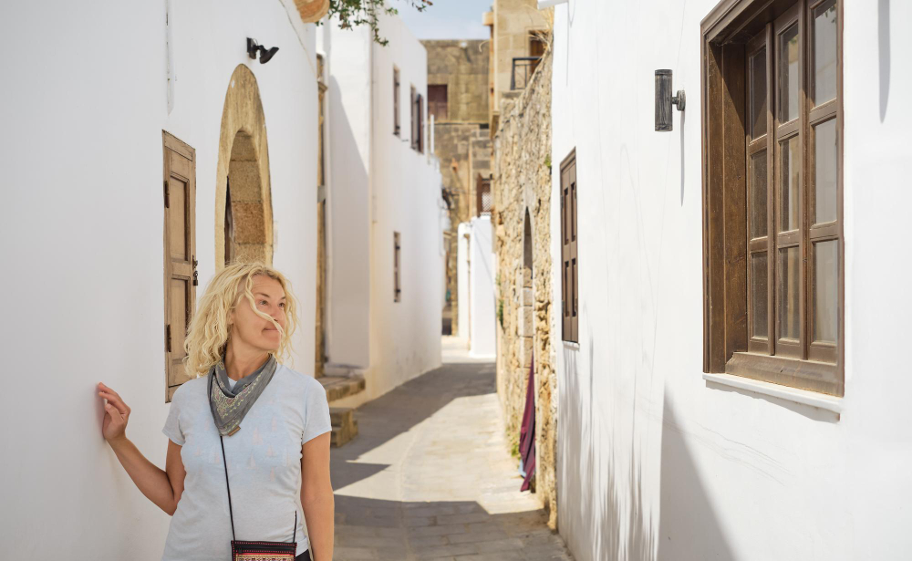 une femme marche dans une ruelle en grèce