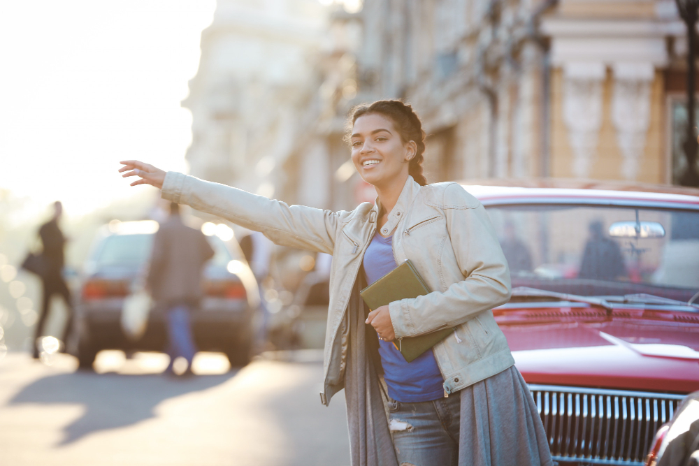 une femme levant la main pour réclamer un taxi